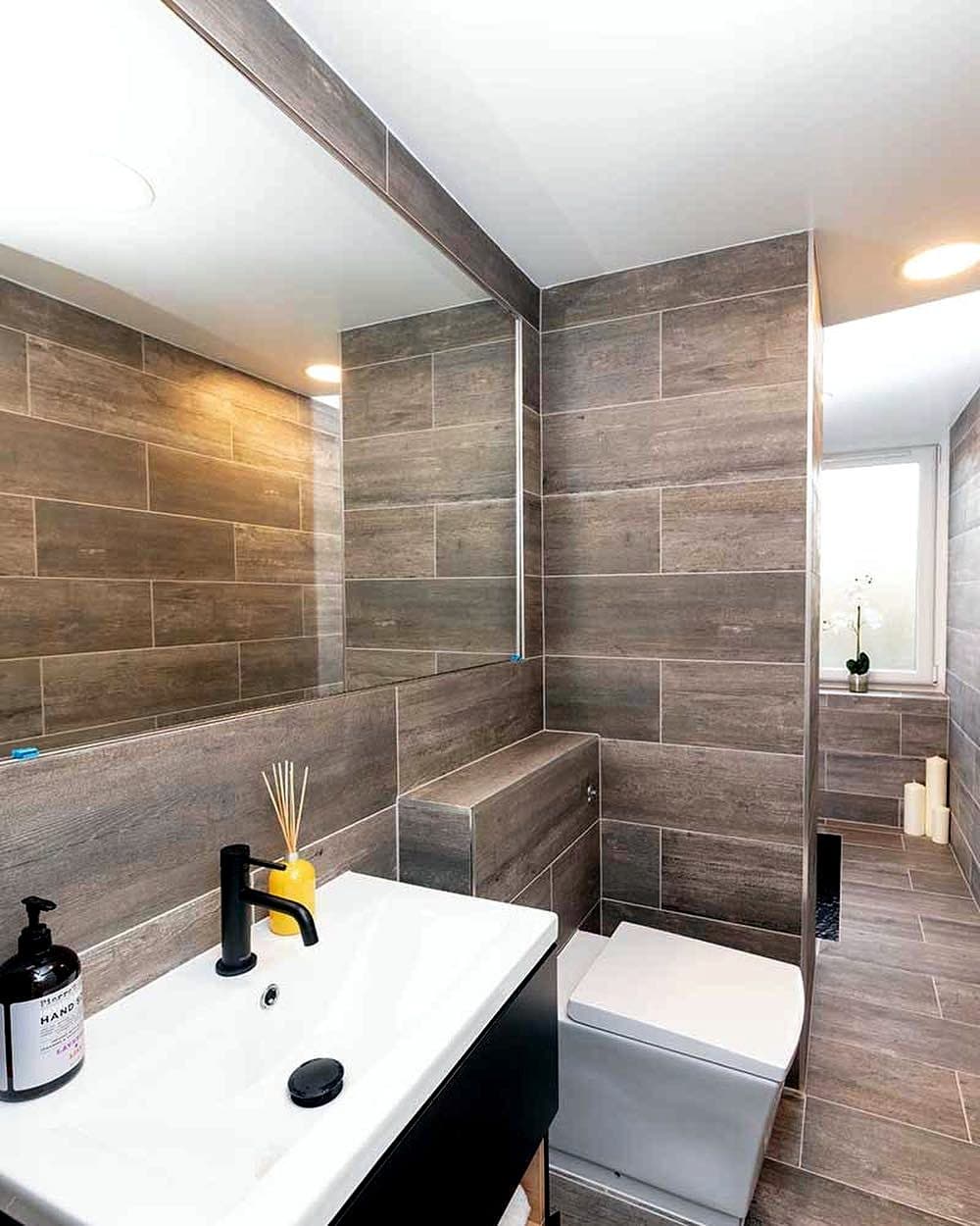 Refitted bathroom with wood-effect tiles and black fittings
