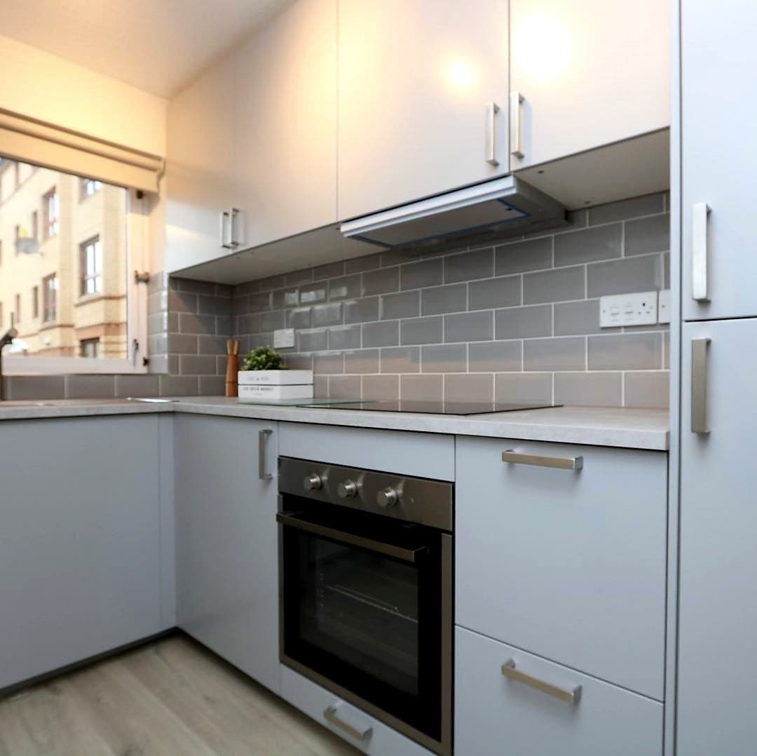 Grey kitchen with Glasgow tenements through the window